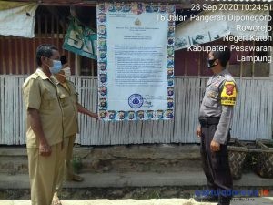 Cegah Covid-19 dikala Pilkada, Bhabinkamtibmas Polsek Gedongtataan Lakukan Pemasangan Banner